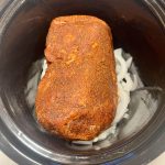 onions and boston butt in a slow cooker